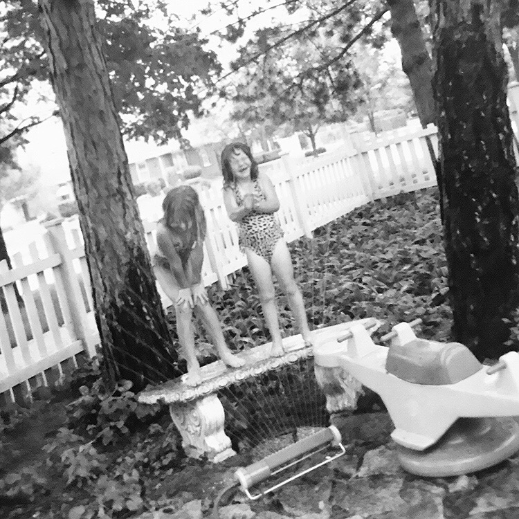  Yesterday my mom sent me this photo of my cousin Rachel and I in her backyard. I was immediately taken back to a flood of memories, my cousins side yard, the sleepovers and family meals, the garage sales and late nights begging for ‘just one more hour”. The simplicity of our humble beginnings as a crazy family.  After seeing this photo I can remember all these moments & how they felt, at some point in being an adult I forgot about this joy I had as a child… like standing on a bench getting sprayed with water, and all the fleeting memories we had growing up. It made me want to find away to bring this little girl with her hands on her knees laughing back into my everyday…to experience life freely.  When my mom sent me this photo & the feeling that washed over me, completely touched to why Our Days is so important. The days you are experiencing right now as a family, will be cherished in a very tangible way as your children pick up the photographs and are taken back to the here & now with such joy and gratitude. Don’t miss these moments, they mean more than you even know.  - Jessica Eileen   